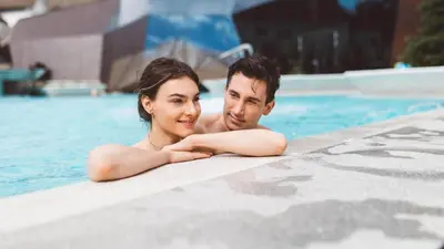 a man and a woman in a swimming pool at Terme Olimia - Aparthotel Rosa in Podčetrtek