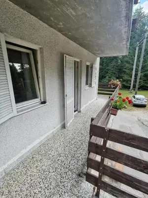 a porch with a bench next to a house at Hostel pod Voglom in Bohinj