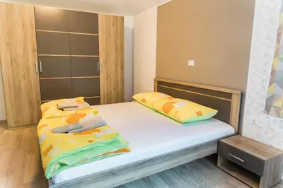 a bedroom with a bed with yellow and green pillows at Guest House Rosi in Tolmin