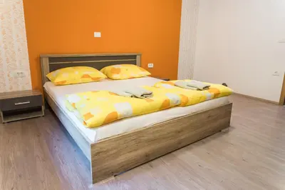 a bedroom with a large bed with yellow sheets and pillows at Guest House Rosi in Tolmin