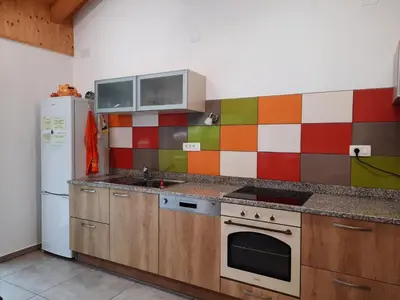 a kitchen with a stove and a refrigerator at Guest House Rosi in Tolmin