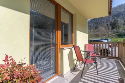 a patio with two chairs and a table on a balcony at Guest House Rosi in Tolmin