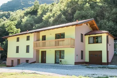 a house in front of a mountain at Guest House Rosi in Tolmin