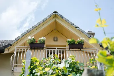 a house with two flower boxes on the balcony at Zidanica-Vineyard Cottage Jakše in Semič
