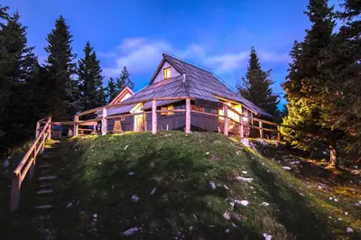 a large wooden house on top of a hill at Koča Bistra - Velika planina in Stahovica