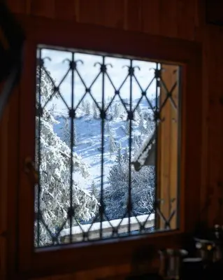 a window with a view of a snow covered mountain at Koča Bistra - Velika planina in Stahovica