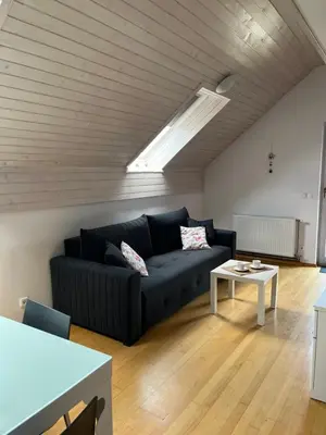 a living room with a black couch and a table at Apartment Story in Kranjska Gora