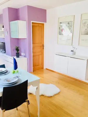 a white and purple kitchen with a table and chairs at Apartment Story in Kranjska Gora