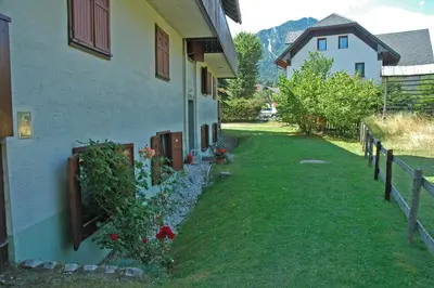 a house with a yard next to a building at Apartment Story in Kranjska Gora