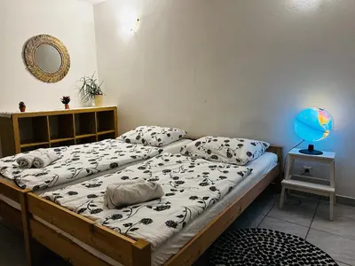 a bedroom with two beds and a mirror at Bright Side Studios in Ljubljana
