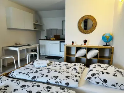 a small room with a bed and a kitchen at Bright Side Studios in Ljubljana