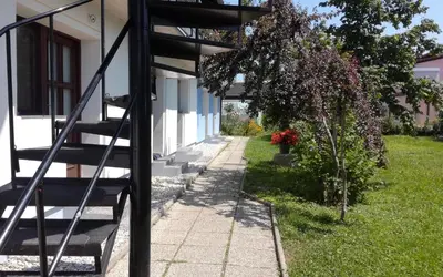 a spiral staircase next to a house with a tree at Bright Side Studios in Ljubljana