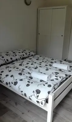 a bed with a black and white comforter on it at Bright Side Studios in Ljubljana