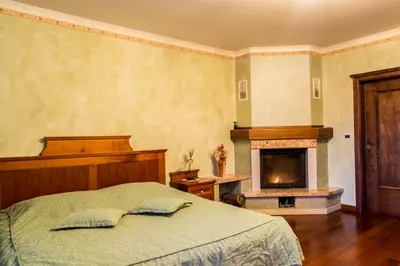 a bedroom with a bed and a fireplace at Domačija pri Damjanu in Kozina
