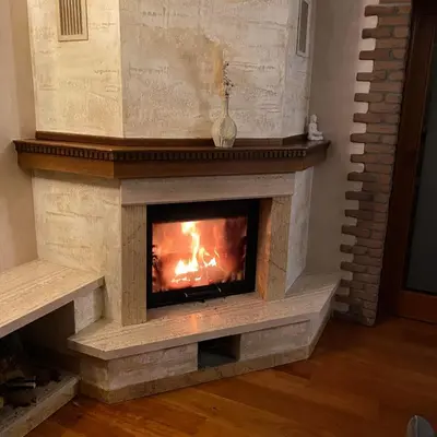 a fireplace in a living room with a fire in it at Domačija pri Damjanu in Kozina