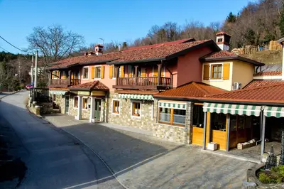 a large building with a balcony on a street at Domačija pri Damjanu in Kozina