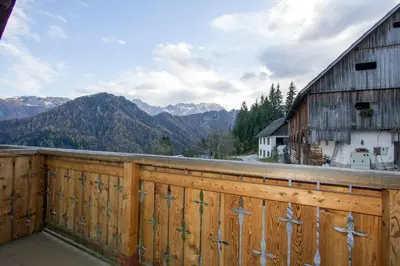 a balcony with a wooden fence and a barn at Kmetija Matk in Solčava