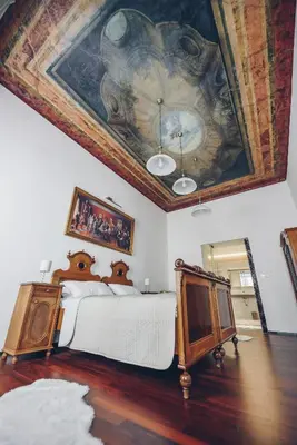 a bedroom with a bed with a painting on the ceiling at Feel Ljubljana Centre in Ljubljana
