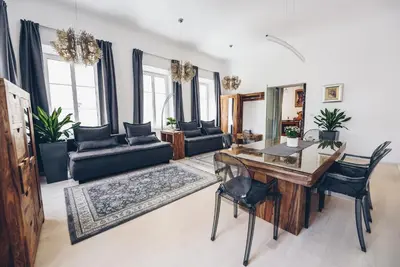 a living room with a wooden table and black chairs at Feel Ljubljana Centre in Ljubljana