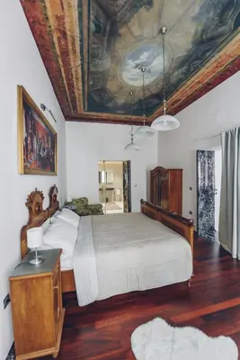 a bedroom with a large bed with a painting on the ceiling at Feel Ljubljana Centre in Ljubljana