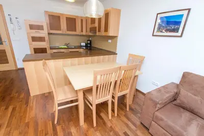 a kitchen and dining room with a table and chairs at Luxury Apartments Bolf in Pohorje