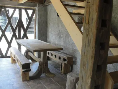 a wooden table and bench in a room with stairs at GOSTel Koprivnik pri Kočevju, Kočevski Rog in Koprivnik