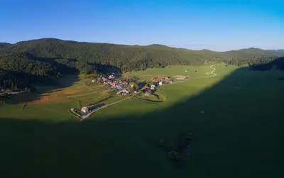 an aerial view of a village in the middle of a lake at GOSTel Koprivnik pri Kočevju, Kočevski Rog in Koprivnik