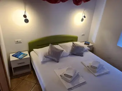 a bedroom with a white bed with two napkins on it at Apartment Pod velbi in Ljubljana