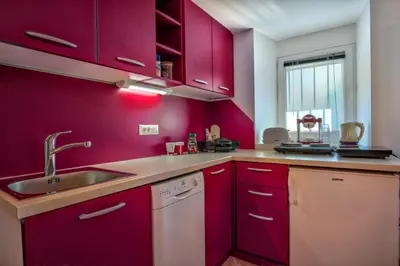 a kitchen with purple cabinets and a sink at Apartment Pod velbi in Ljubljana