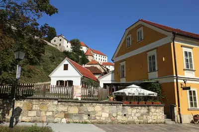 a building with an umbrella in front of a house at Apartment Little house in Ptuj