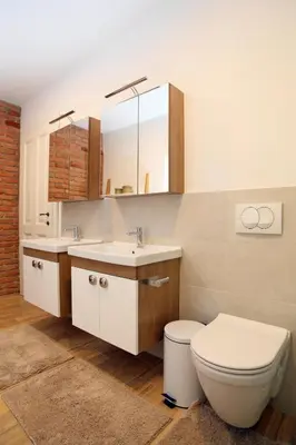 a bathroom with a toilet and two sinks and a mirror at Apartment Little house in Ptuj