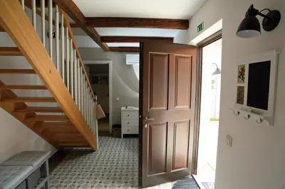 a hallway with a wooden door and stairs at Apartment Little house in Ptuj