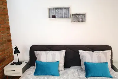 a bedroom with a bed with two pictures on the wall at Apartment Little house in Ptuj