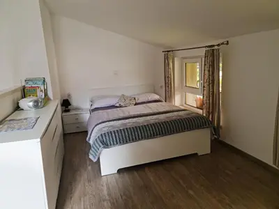 a small bedroom with a bed and a window at Apartmaji Daniel in Kranjska Gora