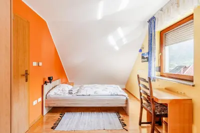 a bedroom with a bed and a desk and a window at Apartment Bruna Vučič in Bovec