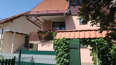 a pink house with a green gate and a fence at Apartment Bruna Vučič in Bovec