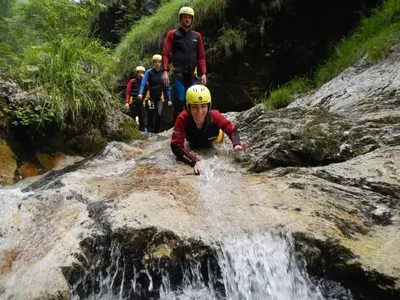 a group of people climbing over a waterfall at Apartment Bruna Vučič in Bovec