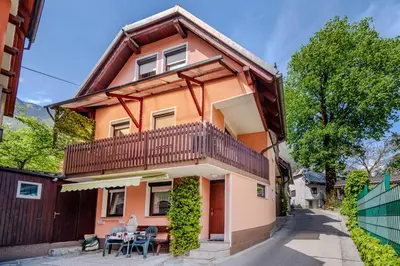 a house with a balcony and a table and chairs at Apartment Bruna Vučič in Bovec