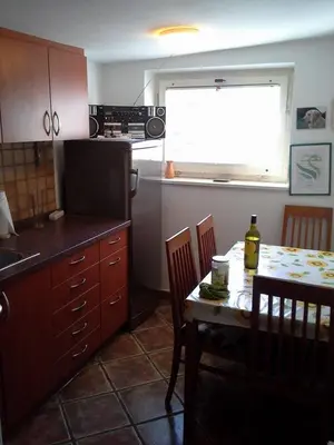 a kitchen with a table and a kitchen with a window at Apartma Pr' Vok in Lesce