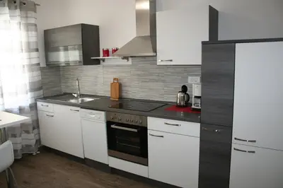 a kitchen with white cabinets and a stove top oven at Apartma Center in Bovec