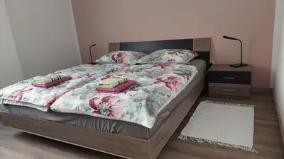 a bedroom with a bed with pink flowers on it at Apartma Center in Bovec