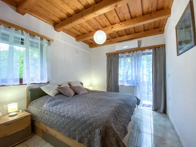 a bedroom with a bed in a room with windows at Apartment Feher Lendava in Lendava