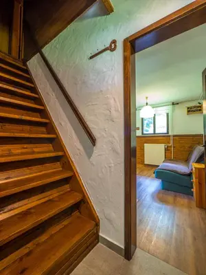 a staircase in a living room with a blue couch at Počitniška hiša Radovna in Zgornja Radovna