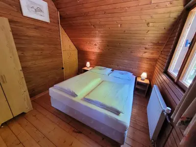 a bedroom with a bed in a wooden room at Počitniška hiša Radovna in Zgornja Radovna