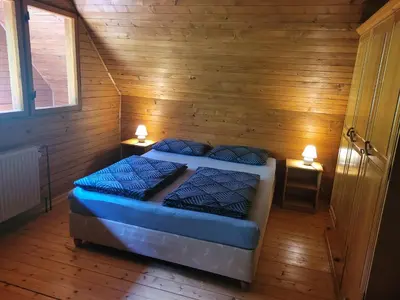 a bedroom with two beds in a wooden room at Počitniška hiša Radovna in Zgornja Radovna