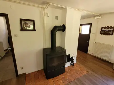 a black stove in a room with a hallway at Počitniška hiša Radovna in Zgornja Radovna