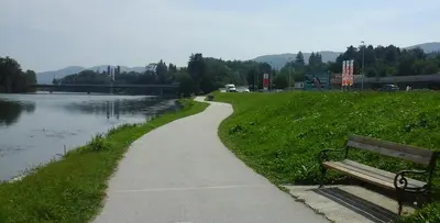 a path next to a bench next to a lake at Ribiški dom Radeče in Radeče