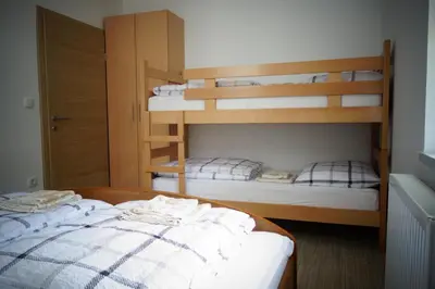 a bedroom with two bunk beds and a bed at Ribiški dom Radeče in Radeče
