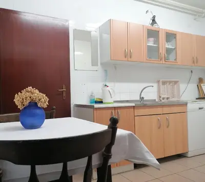 a kitchen with a table with a blue vase on it at Ribiški dom Radeče in Radeče