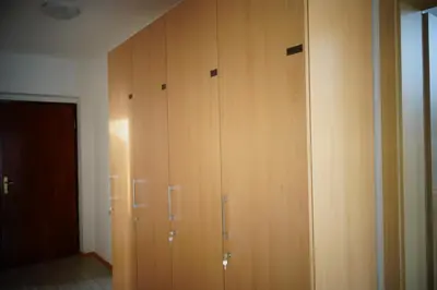 a wooden closet with four lockers in a room at Ribiški dom Radeče in Radeče
